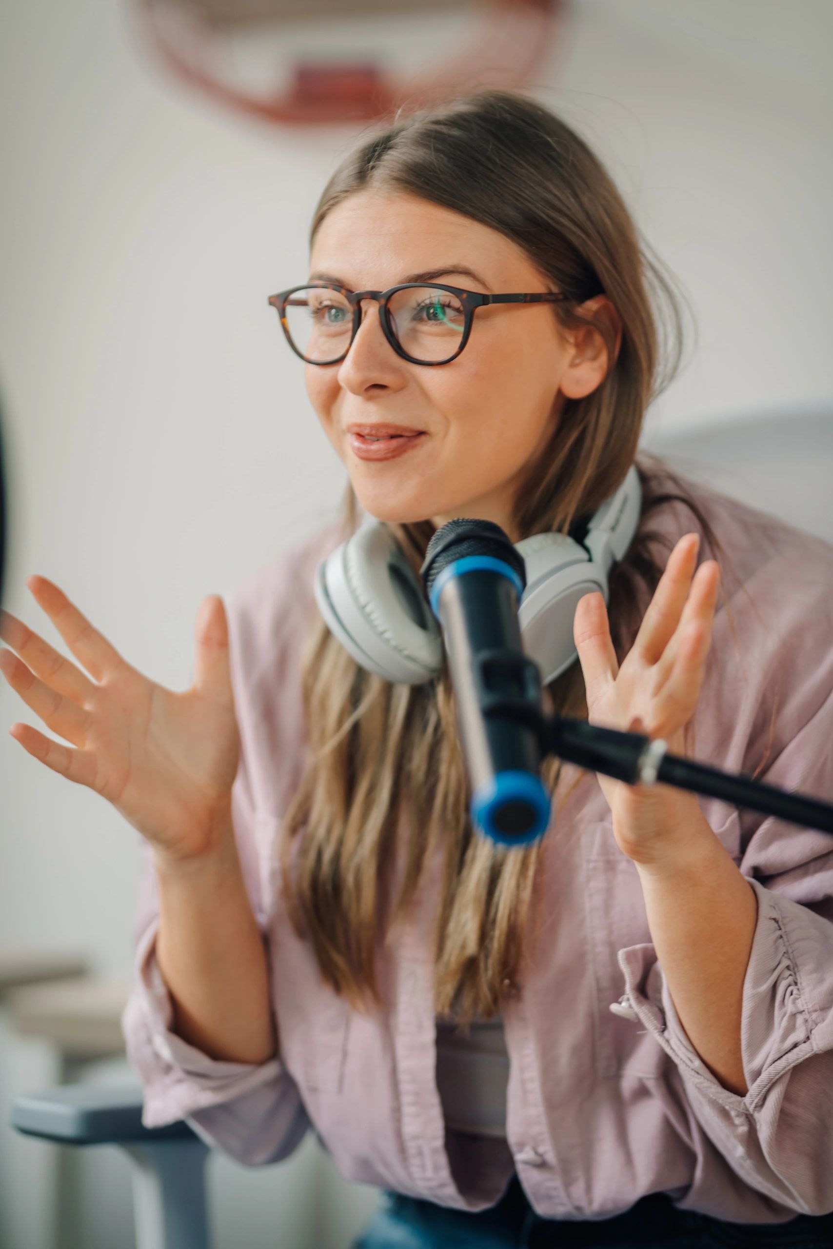 Podcast host speaking into a microphone in a studio
